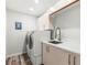 Functional laundry room features a modern washer and dryer, with a utility sink and storage cabinets at 4564 Juniper Dr, Palm Harbor, FL 34685