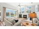 Bright living room with a fireplace, large windows, wood-look floors, and sliding glass doors to the pool at 4564 Juniper Dr, Palm Harbor, FL 34685