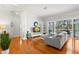Bright living room with hardwood floors, gray sofa, and sliding doors to the outdoor area at 4564 Juniper Dr, Palm Harbor, FL 34685