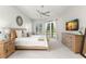 A bright and airy bedroom with neutral tones, wood furnishings, and french door access to the pool at 4564 Juniper Dr, Palm Harbor, FL 34685
