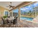 Covered patio with a dining table and chairs overlooking a screened-in pool and landscaped yard at 4564 Juniper Dr, Palm Harbor, FL 34685