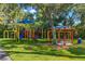 Bright, colorful playground with swings, slide, and picnic shelter on a lush, green lawn at 4564 Juniper Dr, Palm Harbor, FL 34685