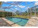 Sparkling pool with screened enclosure, featuring string lights and a scenic view of the outdoors at 4564 Juniper Dr, Palm Harbor, FL 34685