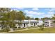 Well-maintained townhome exterior with a lush lawn, mature trees, and convenient parking at 4647 Lake Villa Dr, Clearwater, FL 33762
