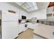 Bright kitchen with white cabinets, appliances, and neutral countertops offers ample storage and cooking space at 4647 Lake Villa Dr, Clearwater, FL 33762