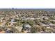 An aerial view of the house surrounded by lush green trees, residential area, and a distant cityscape in the background at 5010 W Dickens Ave, Tampa, FL 33629