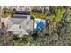 An aerial view of a home with a backyard pool and deck surrounded by lush, mature trees at 5010 W Dickens Ave, Tampa, FL 33629