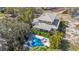 An aerial view of a charming home showcasing a pool, complemented by lush greenery and set against the backdrop of trees at 5010 W Dickens Ave, Tampa, FL 33629