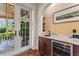 This bar area features custom cabinets, a wine fridge, granite counter tops, and backyard patio access at 5010 W Dickens Ave, Tampa, FL 33629