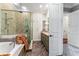 This bathroom features a walk-in shower and vanity with double sinks, as well as wood-look tile flooring at 5010 W Dickens Ave, Tampa, FL 33629