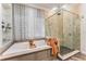 This bathroom features a soaking tub and a walk-in shower with stone tile and glass door at 5010 W Dickens Ave, Tampa, FL 33629