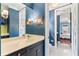 A bathroom featuring blue walls, hexagon tile flooring, modern fixtures, and open doorway to bedroom at 5010 W Dickens Ave, Tampa, FL 33629