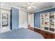 Blue bedroom features hardwood floors, shelving, double closets, and an open doorway to ensuite bath at 5010 W Dickens Ave, Tampa, FL 33629