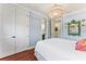 Well-lit bedroom with white bedding, wooden floors, chandelier and attached bathroom at 5010 W Dickens Ave, Tampa, FL 33629