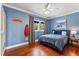 Bedroom features hardwood floors, blue walls, a decorative surfboard, and a window view of the outdoors at 5010 W Dickens Ave, Tampa, FL 33629