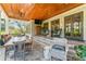 Inviting covered patio features wood ceilings, a dining area, and comfortable lounge seating at 5010 W Dickens Ave, Tampa, FL 33629