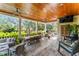 Spacious covered patio with ceiling fans, outdoor seating, dining area, and exterior backyard views at 5010 W Dickens Ave, Tampa, FL 33629