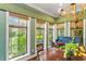 Dining room with a round wood table, a piano, and three large windows overlooking the yard at 5010 W Dickens Ave, Tampa, FL 33629