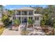 Stately two-story home featuring a metal roof, a brick driveway, and immaculate landscaping at 5010 W Dickens Ave, Tampa, FL 33629