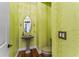 Half-bathroom featuring a pedestal sink, designer wallpaper and decorative sconces at 5010 W Dickens Ave, Tampa, FL 33629