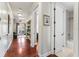 Open hallway with hardwood floors, detailed trim and views to the balcony and bathroom at 5010 W Dickens Ave, Tampa, FL 33629