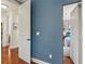 Hallway with hardwood flooring, blue accent wall and view into the bedroom at 5010 W Dickens Ave, Tampa, FL 33629