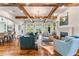 Open concept living room with exposed wood beams, fireplace, and view into kitchen and outdoors at 5010 W Dickens Ave, Tampa, FL 33629