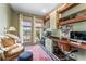 Well-lit office with built-in desk, shelving, and a comfortable seating area by the window at 5010 W Dickens Ave, Tampa, FL 33629
