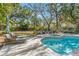 Backyard pool area with lounge chairs, fire pit, and lush landscaping perfect for relaxing and entertaining at 5010 W Dickens Ave, Tampa, FL 33629