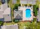 Top-down view featuring a sparkling community pool, surrounded by lounge chairs and lush landscaping at 6428 Thicket Trl, New Port Richey, FL 34653