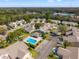 Real estate aerial view of a charming community featuring a pool, well-kept lawns, and mature trees at 6428 Thicket Trl, New Port Richey, FL 34653