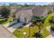 A sunny aerial view of a quaint residential neighborhood showcases well-kept lawns and attached garages at 6428 Thicket Trl, New Port Richey, FL 34653
