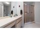 Bathroom features a large mirror, vanity, and a shower with glass doors at 6428 Thicket Trl, New Port Richey, FL 34653