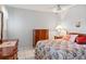 A cozy bedroom with a floral bedspread, wood furniture, and tile flooring at 6428 Thicket Trl, New Port Richey, FL 34653