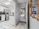 Bright entryway featuring neutral tile flooring, a white door, and an ornate gilded mirror at 6428 Thicket Trl, New Port Richey, FL 34653