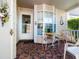 Cozy front porch with tiled floor, table and chairs, and a charming bay window at 6428 Thicket Trl, New Port Richey, FL 34653