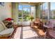 Bright sunroom featuring decorative tile flooring, large windows, and access to a serene outdoor view at 6428 Thicket Trl, New Port Richey, FL 34653