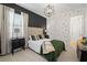 Cozy bedroom with dark accent wall, stylish bedding, and updated light fixture at 7934 Lakes Edge Ln, Port Charlotte, FL 33981
