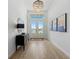 Bright foyer featuring wood-look tile floors, chandelier, and double doors with lots of light at 7934 Lakes Edge Ln, Port Charlotte, FL 33981