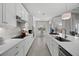 White kitchen with modern appliances, white cabinets, and an island sink at 7970 Lakes Edge Ln, Port Charlotte, FL 33981