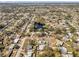 An aerial view showcases a neighborhood dotted with mature trees, homes and community pond at 8040 Owl Rd, Seminole, FL 33777