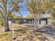 Contemporary gray home featuring a two-car garage, well-maintained landscaping, and a unique driveway at 8040 Owl Rd, Seminole, FL 33777