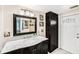 Bathroom featuring a marble countertop, dark wood cabinets, and a large mirror at 8341 Moulton Dr, Port Richey, FL 34668