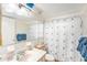 Bathroom with a wide mirror over a marble countertop and a matching patterned shower curtain at 8341 Moulton Dr, Port Richey, FL 34668