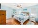 Bright bedroom featuring a ceiling fan, hard wood floors, and a nautical themed bedspread at 8341 Moulton Dr, Port Richey, FL 34668