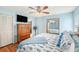 Comfortable bedroom featuring a mounted TV, ceiling fan, and mirrored closet doors at 8341 Moulton Dr, Port Richey, FL 34668