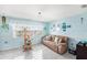 Bright living room with a large window, tile flooring, and comfortable sofa at 8341 Moulton Dr, Port Richey, FL 34668