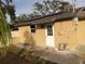 Exterior shot of house with white door and neutral color walls, solar panels above at 9038 Walsingham Rd, Largo, FL 33773