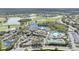 An aerial view of a Primary-planned community featuring a clubhouse, pool, and surrounding golf course at 988 Villeroy Greens Dr, Sun City Center, FL 33573