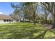 Expansive backyard featuring lush lawn, mature trees, and a well-maintained landscape at 988 Villeroy Greens Dr, Sun City Center, FL 33573